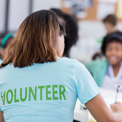 Backshot of a woman with a shirt with the word volunteer printed on it