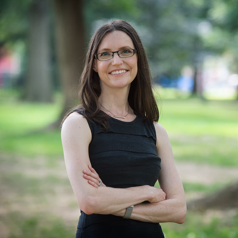 Shot of Dr. Amanda Polack standing outdoors on a park with arms crossed